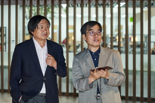 신기남 도서관정보정책위원회 위원장(왼쪽)이 이향철 광운대 중앙도서관장의 안내로 광운대 중앙도서관을 돌아보고 있다.     광운대 제공